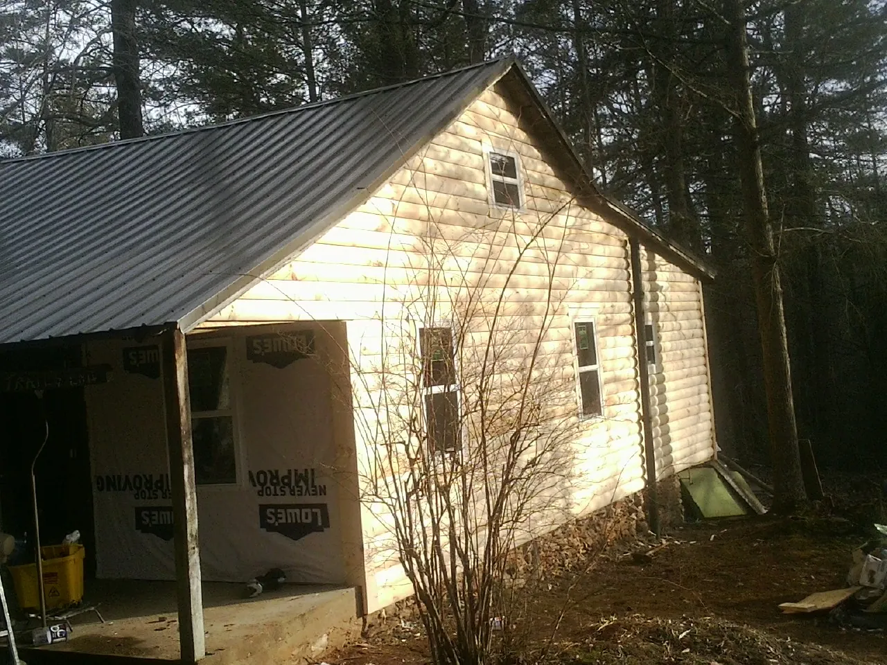 Log siding gable end under a dark metal roof edge in Seagoville