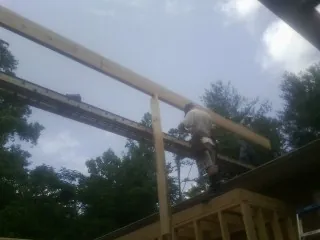 Carpenter setting a ridge beam over a new addition frame — Ice Dam Removal by Roofing Brothers in Seagoville