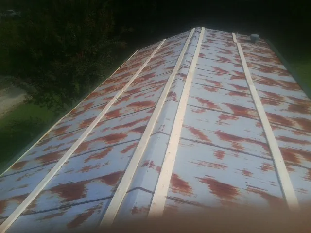 Rusted metal roof panels with new wood purlins before replacement — Storm Damage Roof Repair in Seagoville by Roofing Brothers