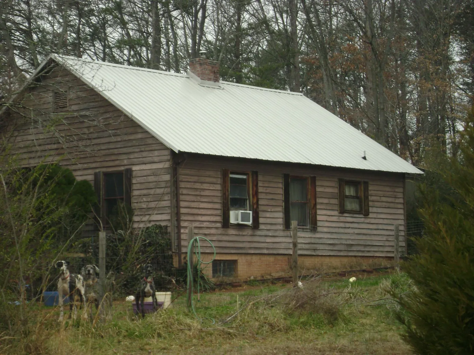 White metal roof on an old wood sided farmhouse, from a Metal Roof Installation job in Seagoville
